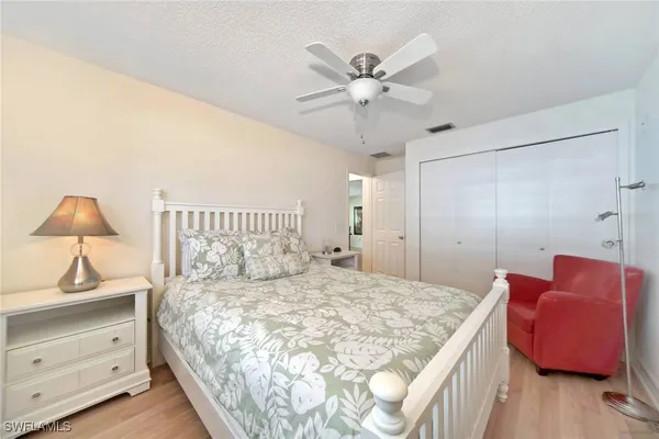 a bedroom with a bed and a lamp on dresser