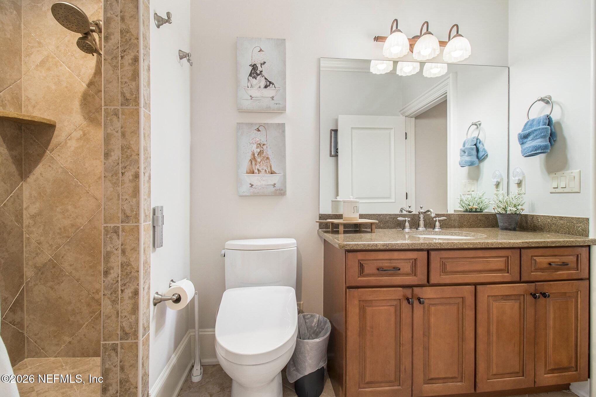 1402 Wilkies Point Road Green Cove Springs, FL 32043 - Photo 55 of 95 a bathroom with a granite countertop sink a toilet and a mirror