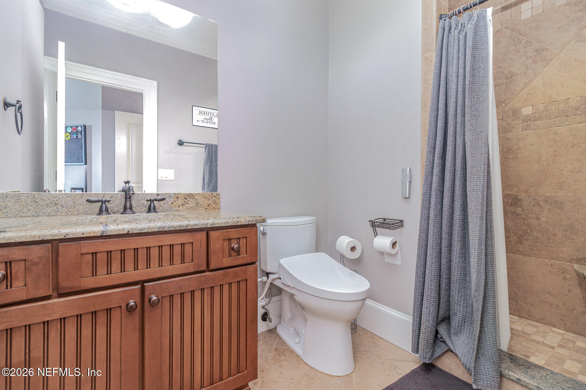 1402 Wilkies Point Road Green Cove Springs, FL 32043 - Photo 57 of 95 a bathroom with a granite countertop toilet a sink and a mirror