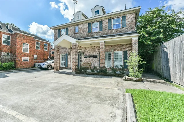 a view of a building with a yard in front of it