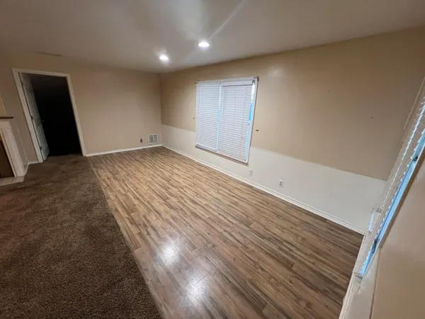 a view of empty room with wooden floor
