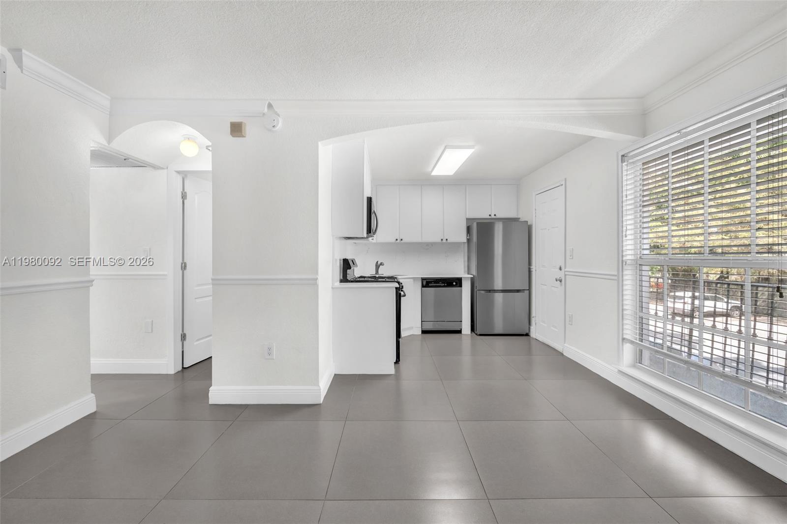 a view of a kitchen with refrigerator and wooden floor