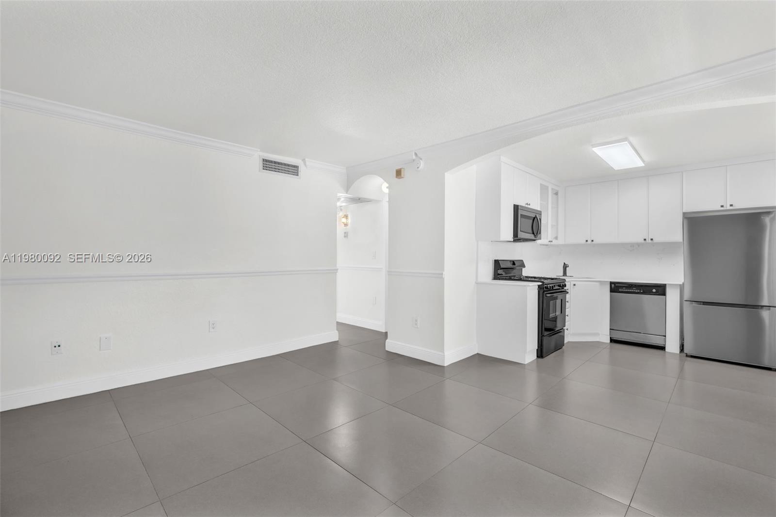 3245 Virginia Street, Unit 26 Miami, FL 33133 - Photo 2 of 26 a view of kitchen with refrigerator cabinets and wooden floor