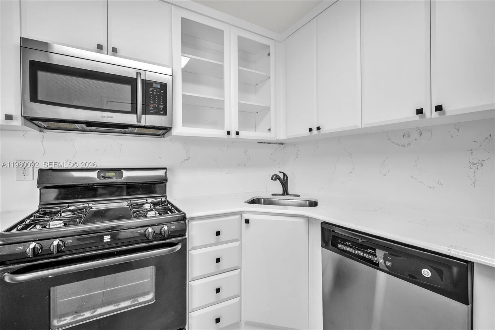 3245 Virginia Street, Unit 26 Miami, FL 33133 - Photo 4 of 26 a kitchen with microwave cabinets and stainless steel appliances