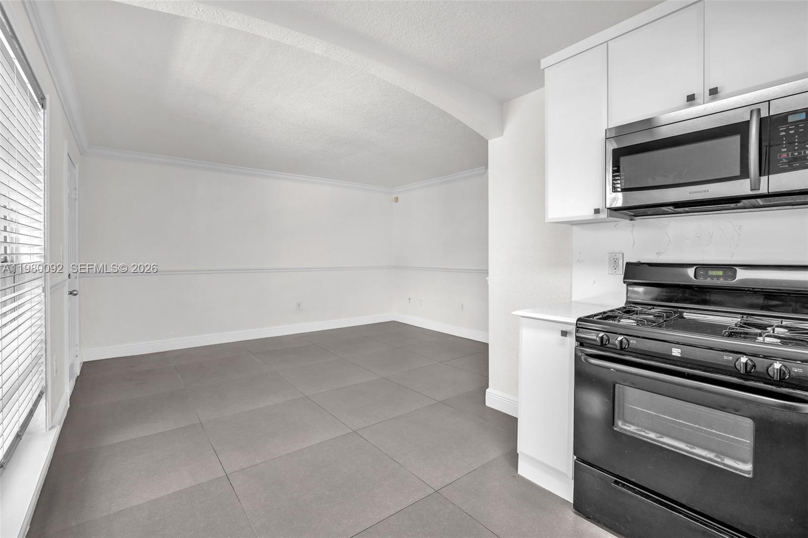 3245 Virginia Street, Unit 26 Miami, FL 33133 - Photo 5 of 26 a kitchen with a stove and a microwave