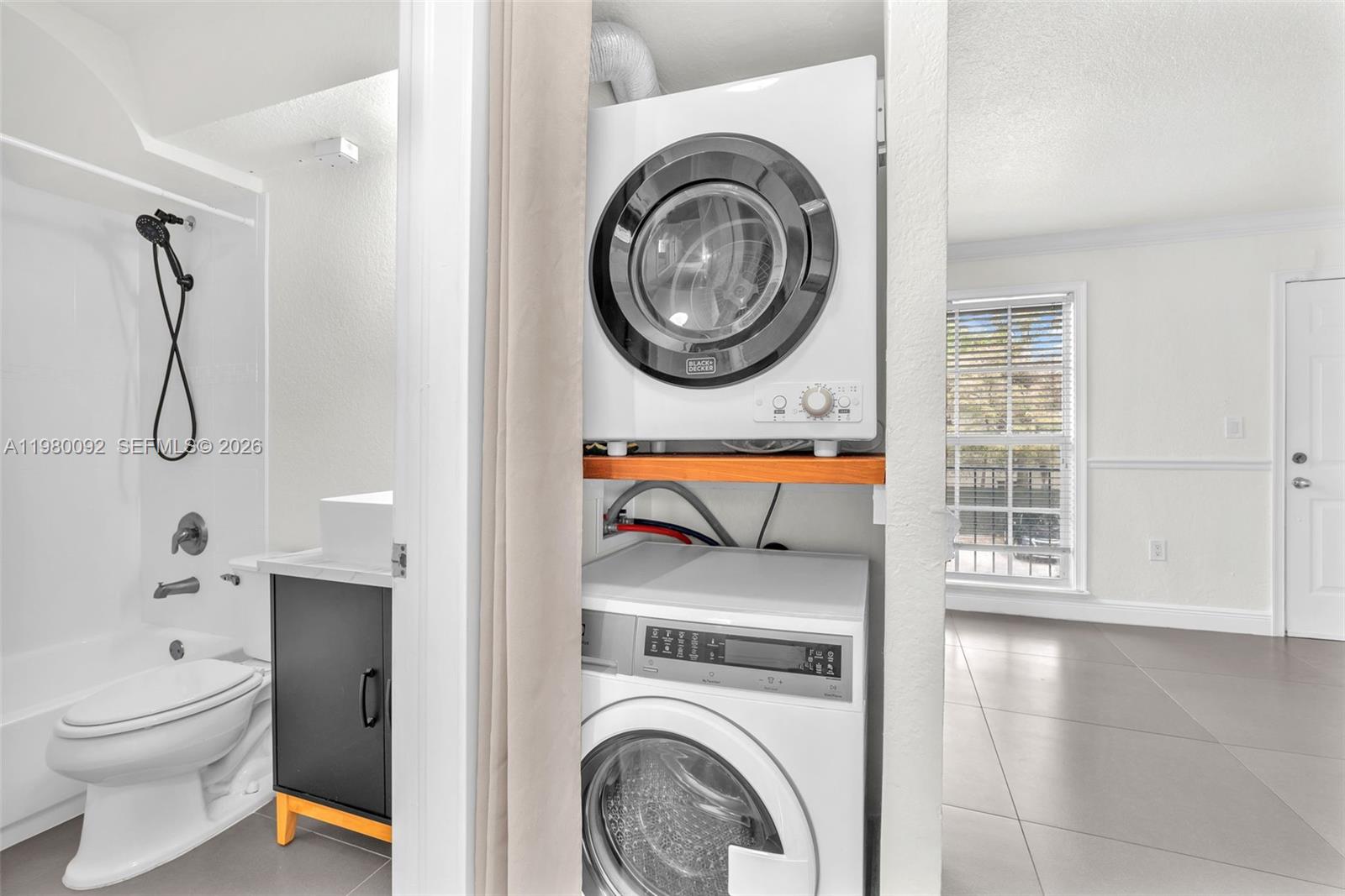 3245 Virginia Street, Unit 26 Miami, FL 33133 - Photo 7 of 26 a view of a bathroom with washing machine and fan