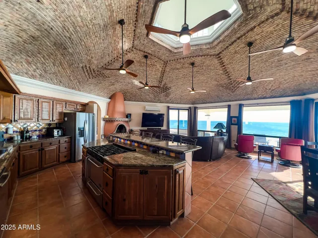 a kitchen with stainless steel appliances granite countertop a stove a sink and a refrigerator