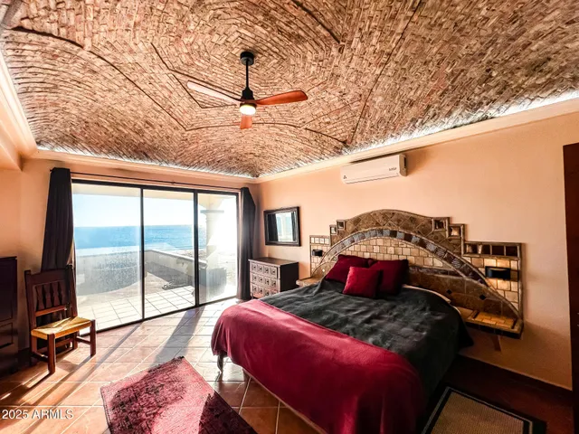 a bedroom with a bed a bookshelf and a large window