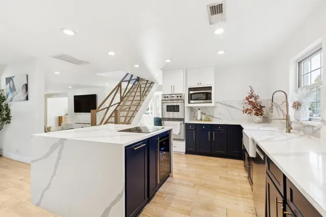a large kitchen with a table chairs refrigerator and stove