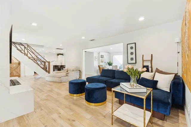 a living room with furniture a flat screen tv and a large window