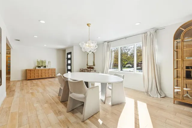a large white kitchen with a sink and a refrigerator