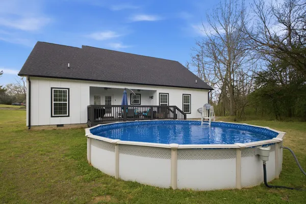 a view of a house with pool and chairs