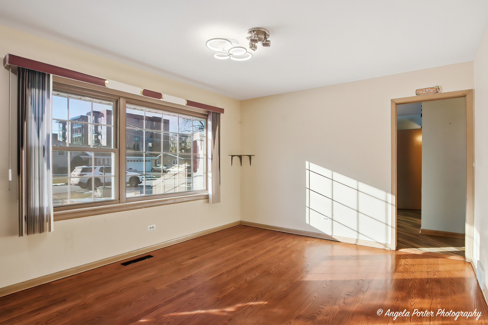 1913 Rancho Lane Des Plaines, IL 60016 - Photo 4 of 36 a view of an empty room with a window and wooden floor