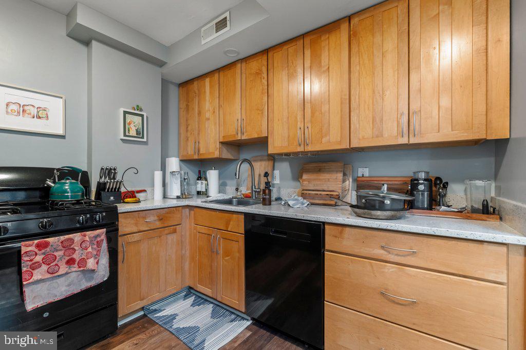 1215 John Street Baltimore, MD 21217 - Photo 14 of 34 a kitchen with stainless steel appliances granite countertop a stove a sink and a microwave