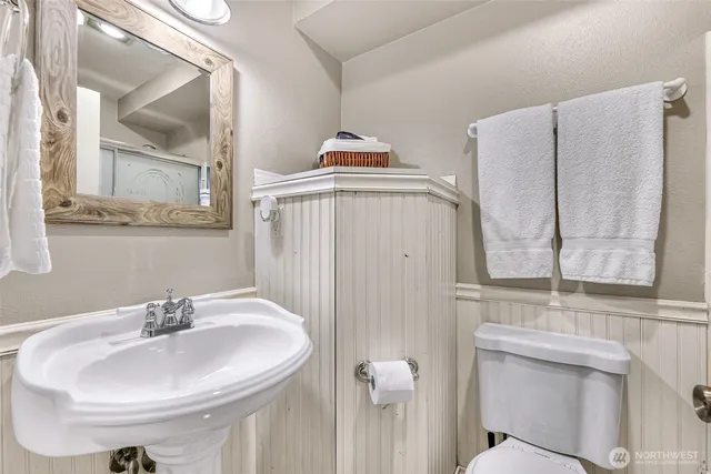 a bathroom with a sink a toilet and a mirror