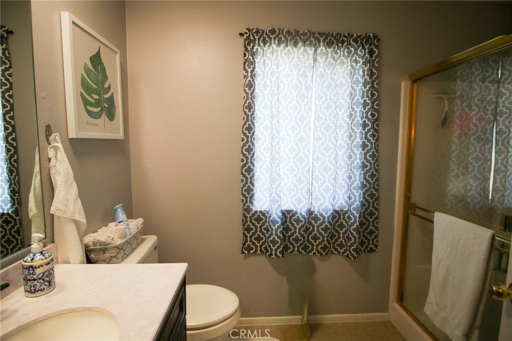 25669 Warwick Road Menifee, CA 92586 - Photo 12 of 36 a bathroom with a toilet and shower curtain