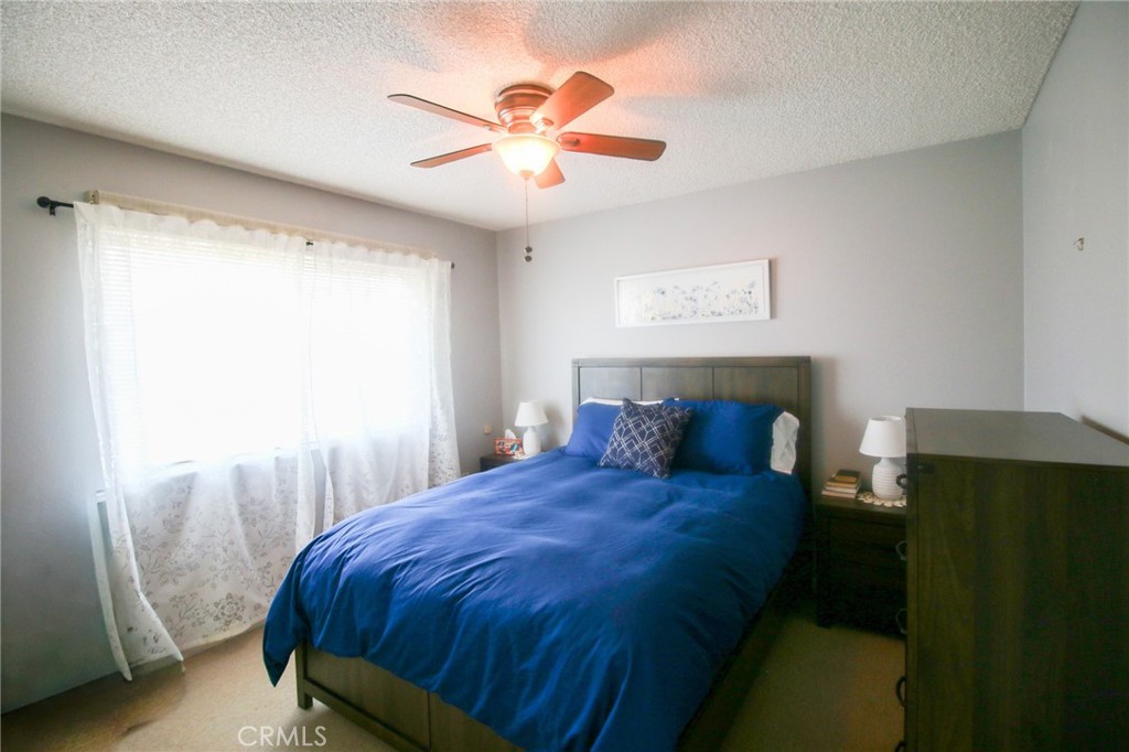 25669 Warwick Road Menifee, CA 92586 - Photo 13 of 36 a bedroom with a bed and a chandelier