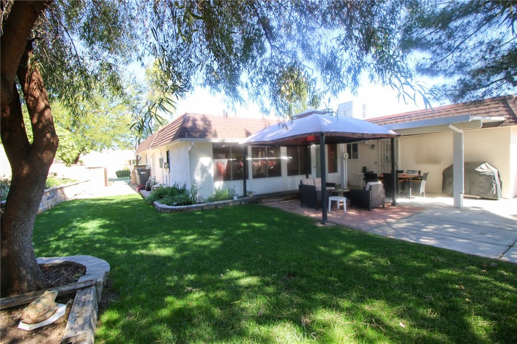 25669 Warwick Road Menifee, CA 92586 - Photo 20 of 36 a view of a patio with table and chairs under an umbrella