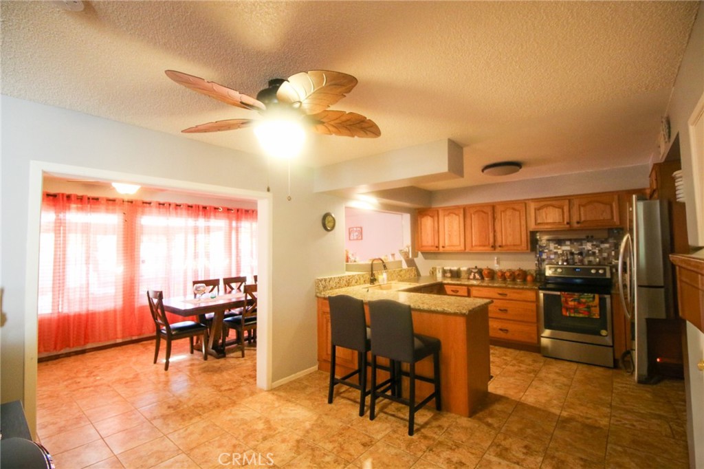 25669 Warwick Road Menifee, CA 92586 - Photo 7 of 36 a dining room with furniture and a kitchen view