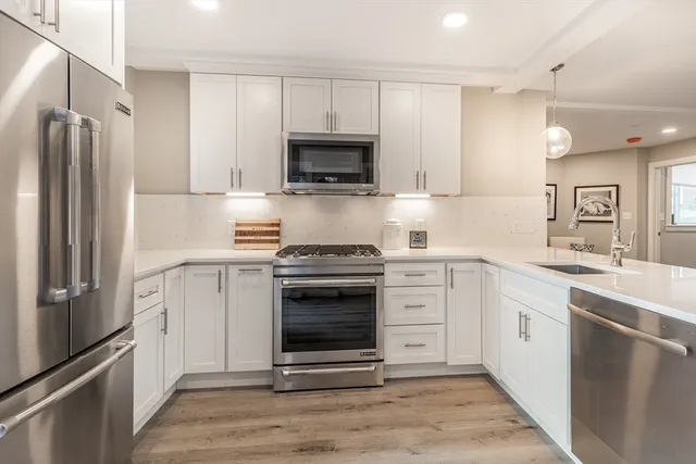 a kitchen with cabinets stainless steel appliances and a counter space
