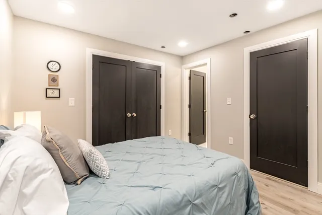 a bedroom with a large bed and wooden floor