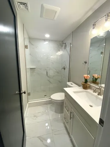 a bathroom with a double vanity sink toilet and shower