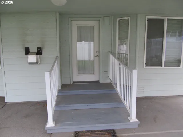 a view of a room with a door open and a microwave