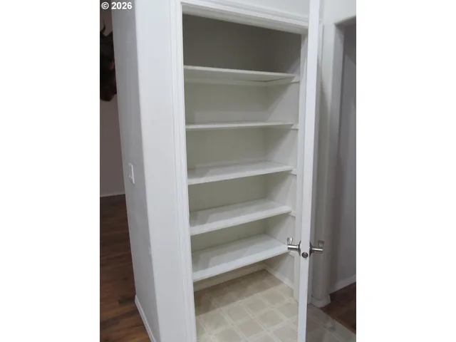 a view of walk in closet with empty racks