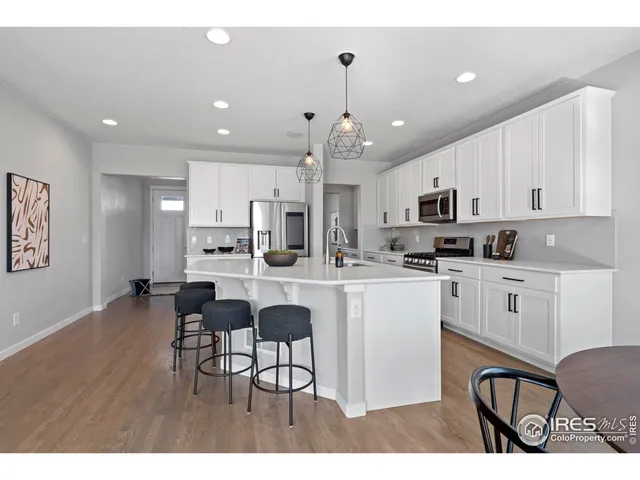 a kitchen with white cabinets stainless steel appliances and kitchen island