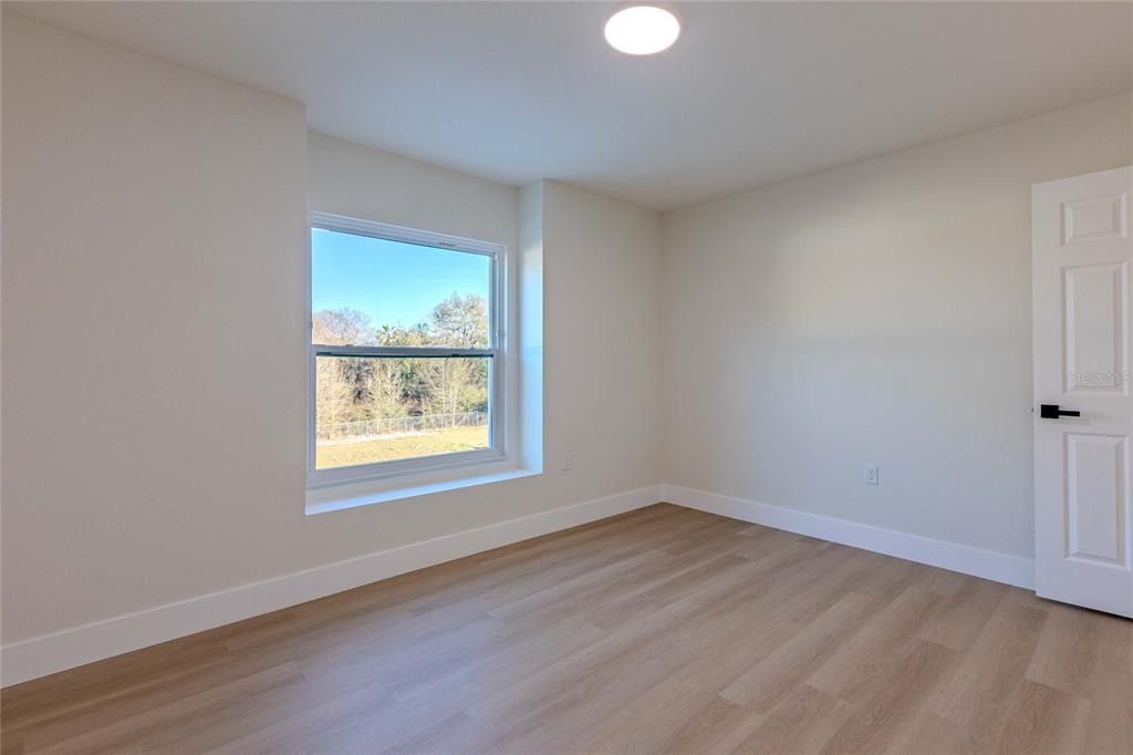 3324 Haystack Road Wesley Chapel, FL 33543 - Photo 15 of 91 an empty room with wooden floor and windows