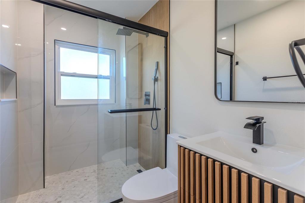 3324 Haystack Road Wesley Chapel, FL 33543 - Photo 17 of 91 a bathroom with a toilet sink shower and mirror