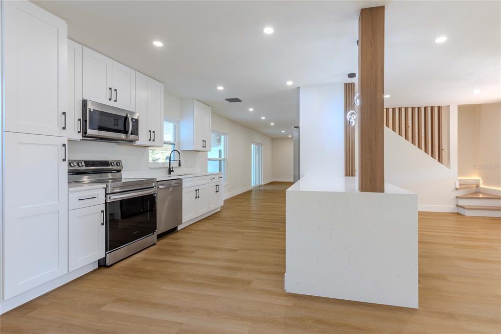 3324 Haystack Road Wesley Chapel, FL 33543 - Photo 31 of 91 a large kitchen with stainless steel appliances granite countertop a stove a sink and a refrigerator