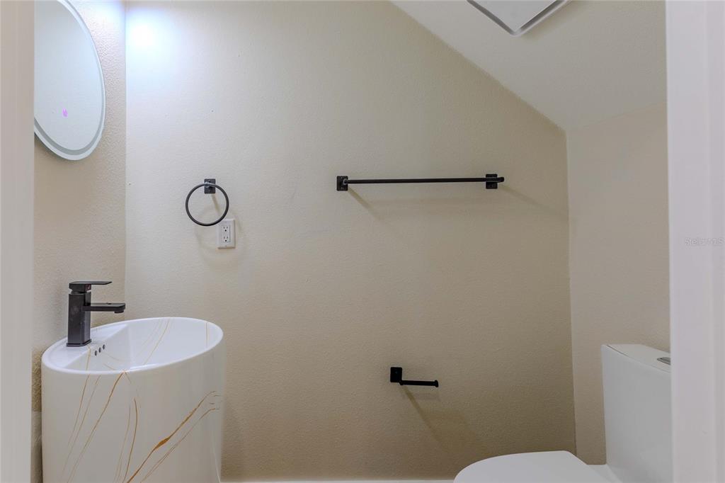 3324 Haystack Road Wesley Chapel, FL 33543 - Photo 45 of 91 a bathroom with a sink a toilet and a mirror