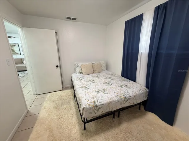 a bedroom with a bed and a window