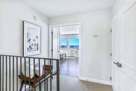 a view of a hallway with a wooden floor and a bathroom