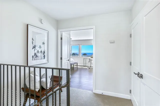 a view of a hallway with a wooden floor and a bathroom