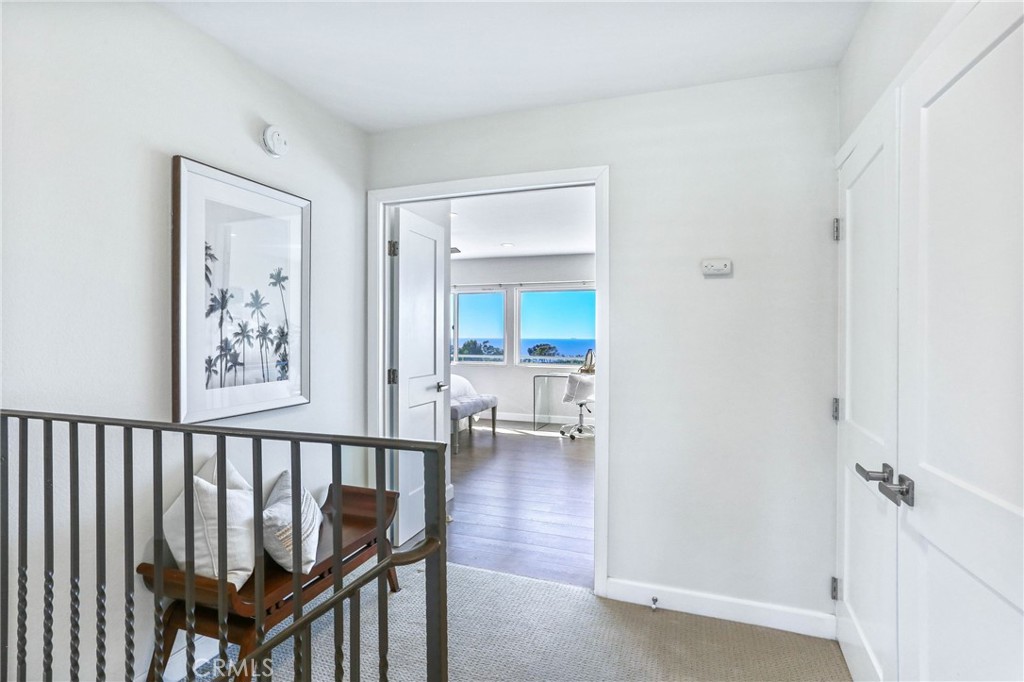 33885 Manta Court Dana Point, CA 92629 - Photo 9 of 34 a view of a hallway with a wooden floor and a bathroom