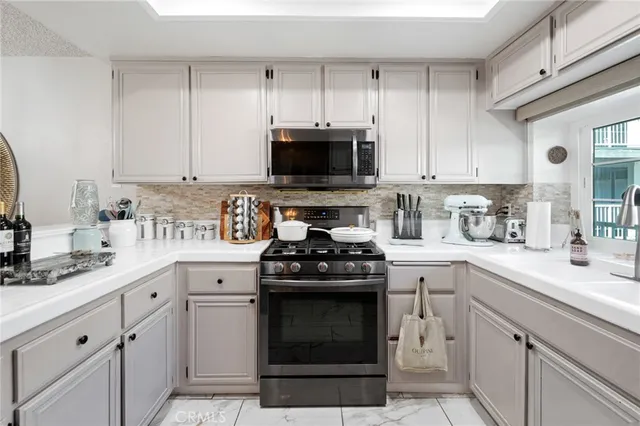 a kitchen with white cabinets and black appliances