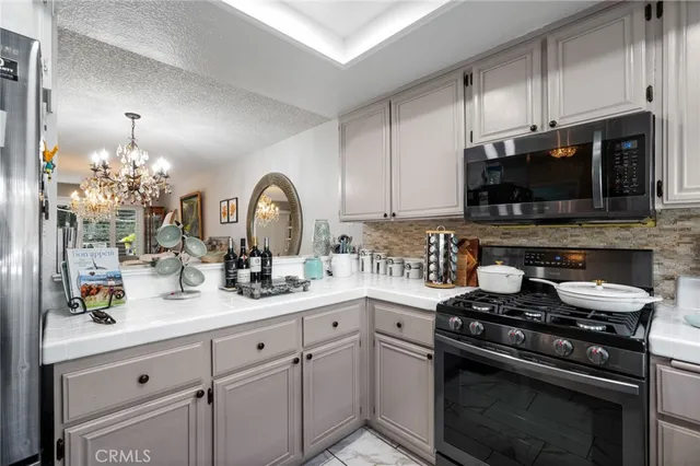 a kitchen with stainless steel appliances granite countertop a sink stove and cabinets