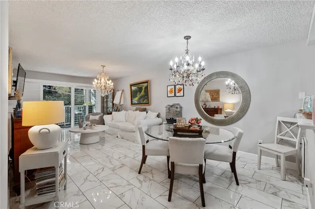 a living room with furniture a chandelier and a mirror