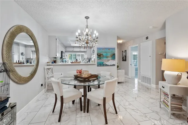 a view of a dining room with furniture and a chandelier
