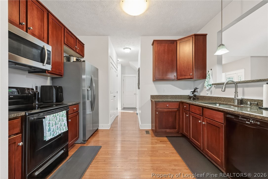 124 Riviera Lane Sanford, NC 27332 - Photo 13 of 45 a kitchen with stainless steel appliances granite countertop a stove a sink and a microwave