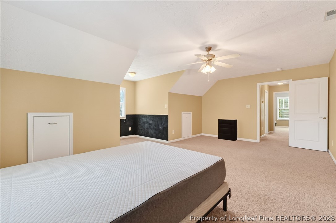 124 Riviera Lane Sanford, NC 27332 - Photo 27 of 45 a spacious bedroom with a large bed a fireplace and a chandelier
