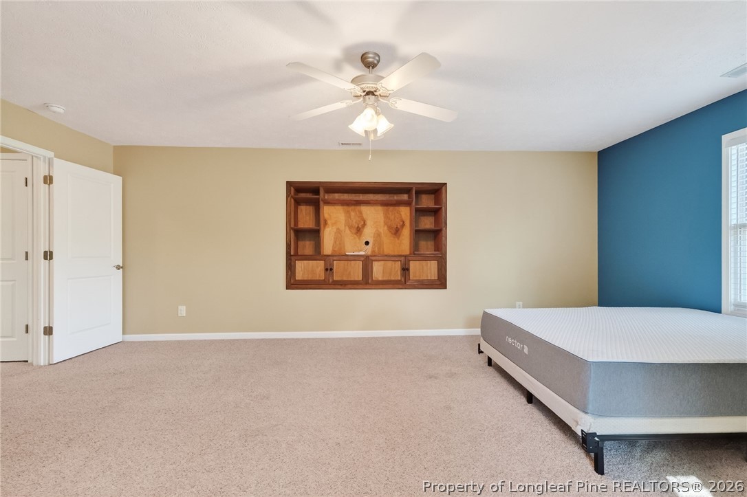 124 Riviera Lane Sanford, NC 27332 - Photo 29 of 45 a bedroom with a bed and a chandelier