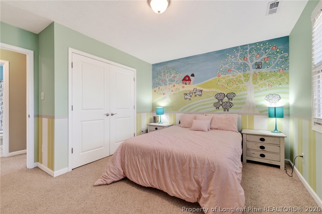 124 Riviera Lane Sanford, NC 27332 - Photo 30 of 45 a bedroom with a bed and a lamp on the dresser