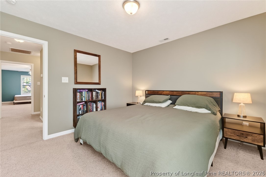 124 Riviera Lane Sanford, NC 27332 - Photo 33 of 45 a bedroom with a bed and a chandelier