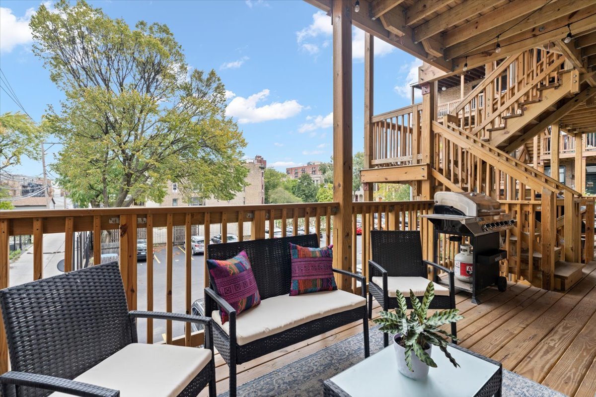 1048 West Lawrence Avenue, Unit 2 Chicago, IL 60640 - Photo 15 of 16 a balcony with wooden floor and outdoor seating