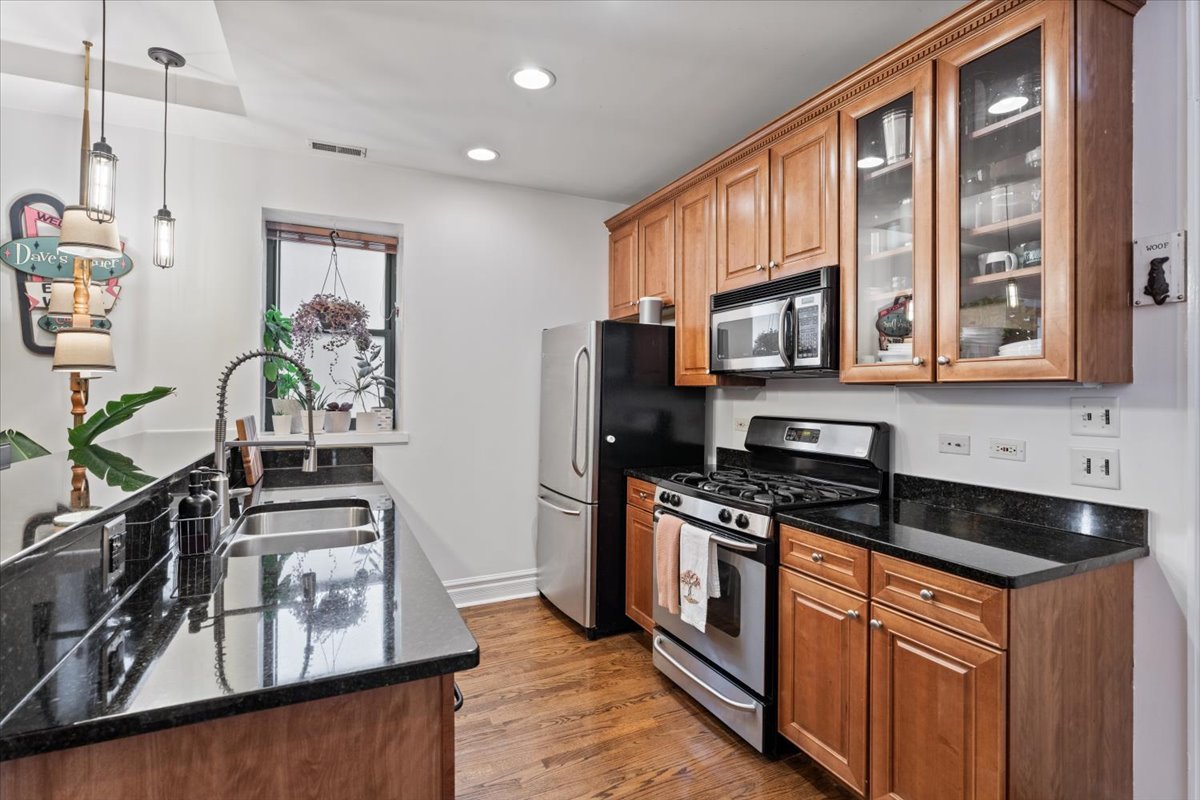 1048 West Lawrence Avenue, Unit 2 Chicago, IL 60640 - Photo 5 of 16 a kitchen with stainless steel appliances granite countertop a stove a sink and a microwave