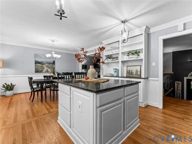 a kitchen with stainless steel appliances granite countertop a table and chairs in it