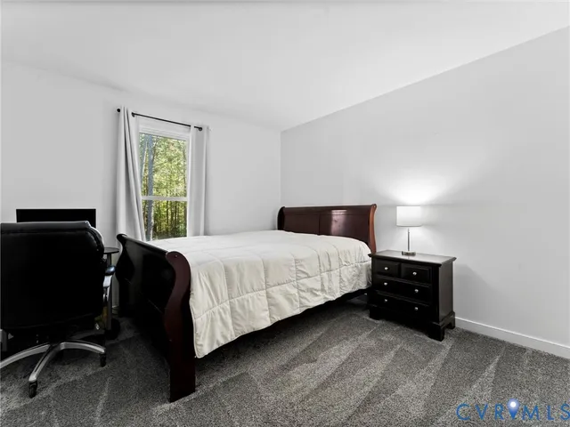 a living room with furniture flat screen tv and a large window